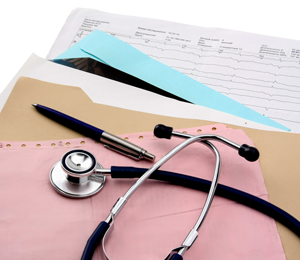 Picture of some files with a pen and stethoscope sitting on top of the files and papers 